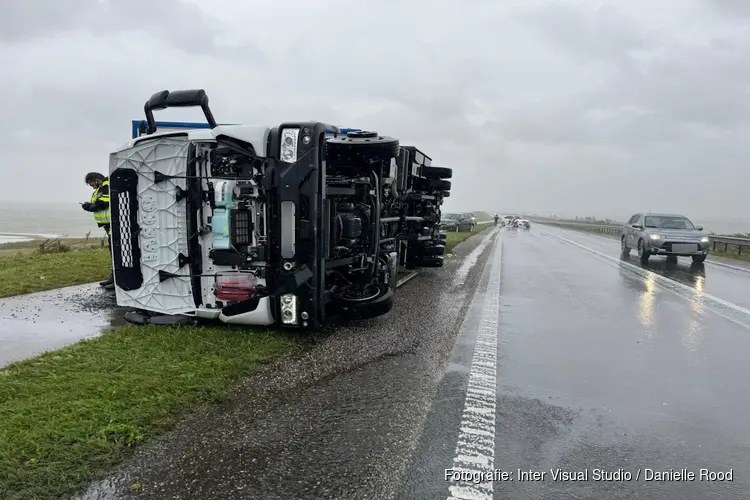 Vrachtwagen waait om door harde wind op de Markerwaarddijk